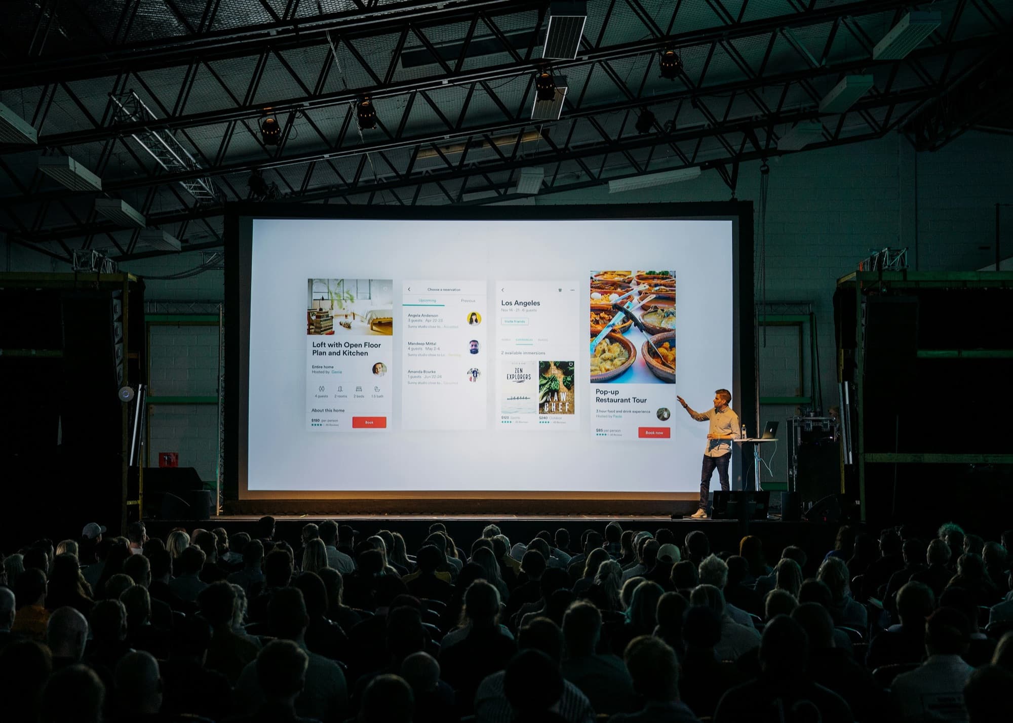 Speaker in front of a large screen and audience